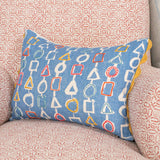 Decorative pillow with hand embroidery on a geometric pattern on a patterned sofa